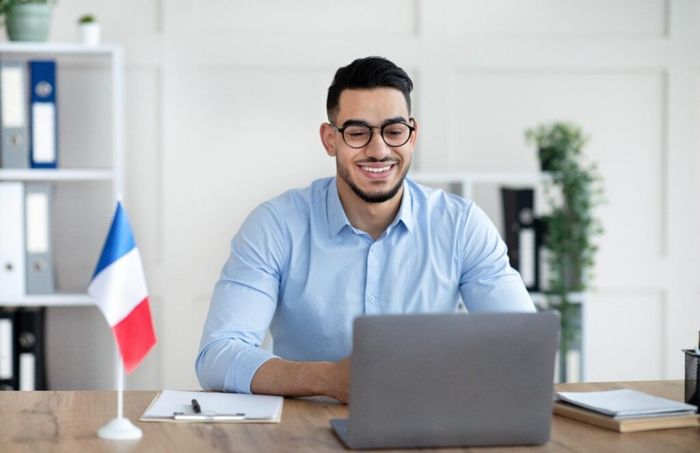 Adult learner joining an online French session from a desk